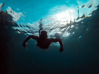 Fototapeta na wymiar Underwater photo of man snorkeling in a sea