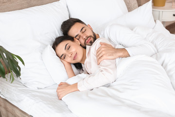 Young couple sleeping in bed at home