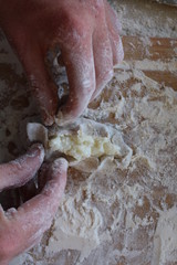 Obraz premium Stage of preparation of Karelian pies -Pirakka. Pies are located on a wooden board, being filled ready for baking. Dish of national cuisine - piirakka. Close-up.