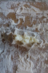 Stage of preparation of Karelian pies -Pirakka. Pies are located on a wooden board, being filled ready for baking. Dish of national cuisine - piirakka. Close-up.