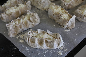 Cooked Karelian pies - Pirakka on a baking sheet. Dish of national cuisine - piirakka. Close-up.