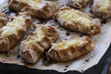 Cooked Karelian pies - Pirakka on a baking sheet. Dish of national cuisine - piirakka. Close-up.