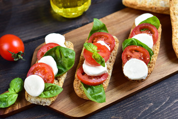 bruschetta with tomatoes, mozzarella and Basil, Caprese salad on toast. typical Italian antipasti starter in a restaurant in Italy Rome Milan. tomato bruschetta recipe, selective focus