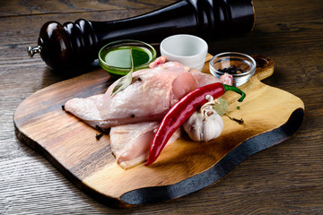 Set raw chicken on cutting board on the wooden background
