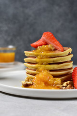 pancake with orange jam, nuts and fresh strawberries. Breakfast food in the morning. pancake recipe. selective focus and copy space. home cooking recipe