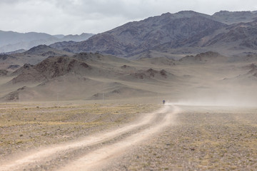 Man riding a motorbike in the steppes of Mongolia, on the hills of Mongolia