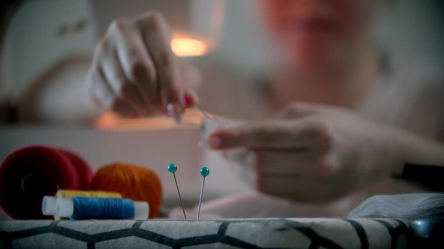 Young woman designer putting pins in the holder