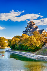 Okayama Crow Castle or Ujo Castle in Okayama City on the Asahi River in Japan. With Little Boat In Foreground.