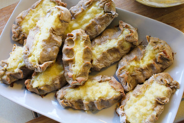 Cooked Karelian pies - Pirakka on a baking sheet. Dish of national cuisine - piirakka. Close-up.