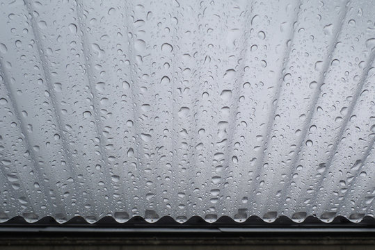 トタン屋根・水滴・くもり空 - Corrugated plastic roof and water droplets with cloudy sky background