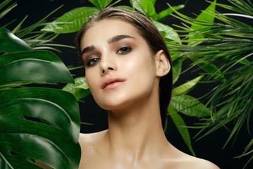 Pretty woman naked shoulders green leaves nature cream health