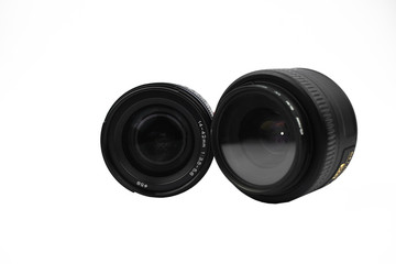 Camera lens of black color and its cap placed on an isolated empty white background