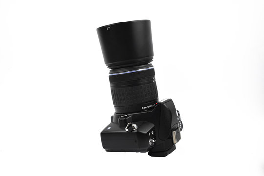 Image of a black colored camera with lens attached to it placed on a white background