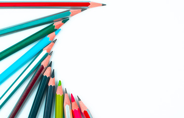 Different colored wood pencil crayons arranged in a half circle pattern on a white background