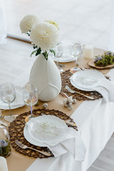 Decorated festive table for traditional holiday dinner, with eggs, spring flowers, napkins. Home table setting decor, white and brown colors. Happy easter concept
