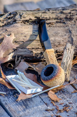 African block Meerschaum pipe resting  in a rural setting with a box of matches 