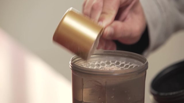 Serving A Portion Of Protein Powder Into The Shaker bottle