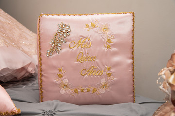 Pink quinceanera pillow with details in gold.