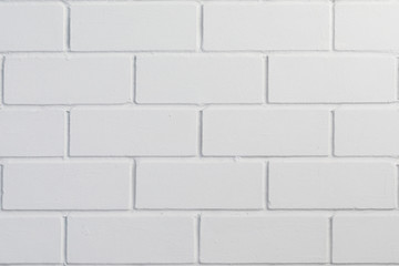 The new brick wall is covered in white paint. Background for design on the theme of construction or architecture.