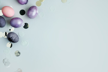 Painted Eggs. silver serpantine and confetti on grey background, flat lay. copy space. Happy Easter day greeting card.