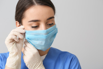 Doctor wearing medical mask against grey background