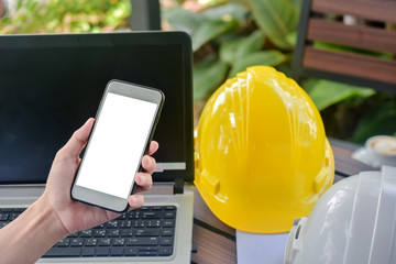Man use mobile smart phone computer hard hat on desk