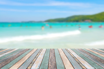 Wood table top with blurred people at the beach