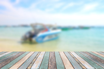 Wood table top with blurred boat at the beach