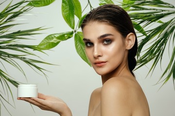 Beautiful woman naked shoulders green leaves clean skin cream spa treatments