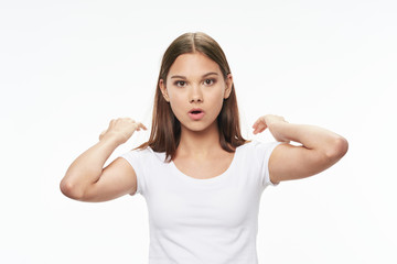 The girls in a white T-shirt are gesticulating with their hands