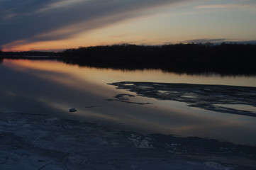 sunset over ice thaw on lake