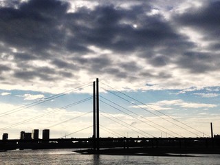 View Of Bridge Over River Against Cloudy Sky
