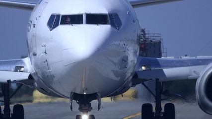 Airplane is on the taxiway. Front view. Pilot waves his hand through the windshield