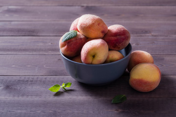 Fototapeta na wymiar bowl with some peaches on wooden table