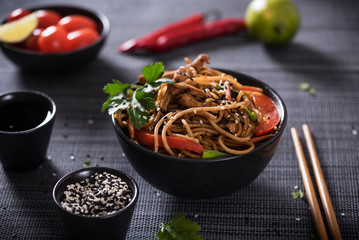 Japanese dish buckwheat noodles soba with chicken and vegetables carrots, bell peppers, mushrooms, green onions