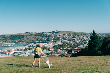 Young attractive walking with a dog in the park Oamaru, New Zealand.