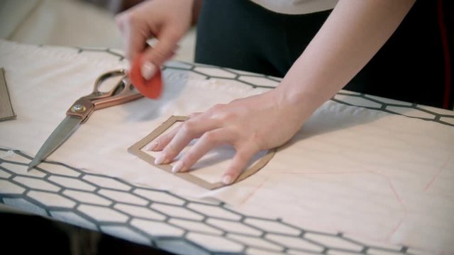 Young woman seamstress making marks using the soap and cartoon form
