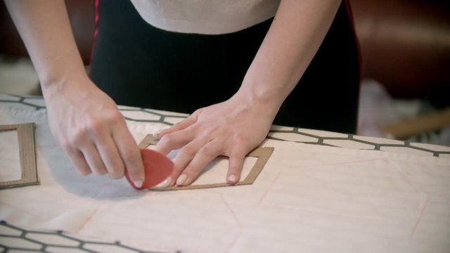 Young woman seamstress making marks using the soap and form indoors