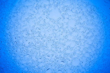 Rain droplets on blue glass background, Water drops on blue glass.