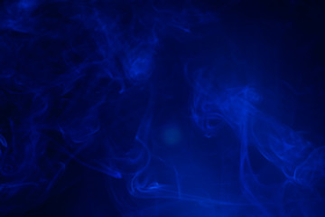 Blue smoke on black background.