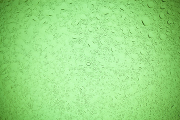 Rain droplets on green glass background, Water drops on green glass.