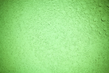 Rain droplets on green glass background, Water drops on green glass.