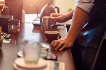 barista making cappuccino. Pouring milk for prepare cup of coffee. Latte art.