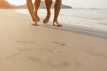 Romantic couple holding hands and walking on beach. Man and woman in love.