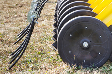 Part of agricultural rotary harrow on cultivated field. Modern technology in agriculture concept