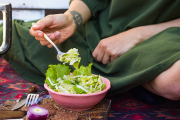 Fresh grated, chopped cabbage salad. Detox vegan food. Woman legs and hands.