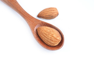 Organic almonds seed in wooden spoon top view isolated on a white background. Healthy food.