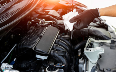 Car mechanic working in repair garage, Pulling the dipstick to checking engine oil level