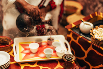 Traditional african barista preparing coffee as in its origin as a steaming hot beverage. Blurred...