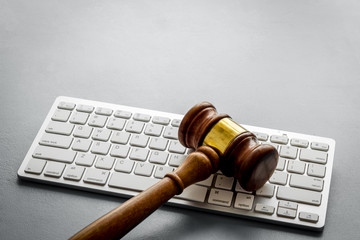 Judge gavel near keyboard - desk of contemporary lawyer - on grey background copy space